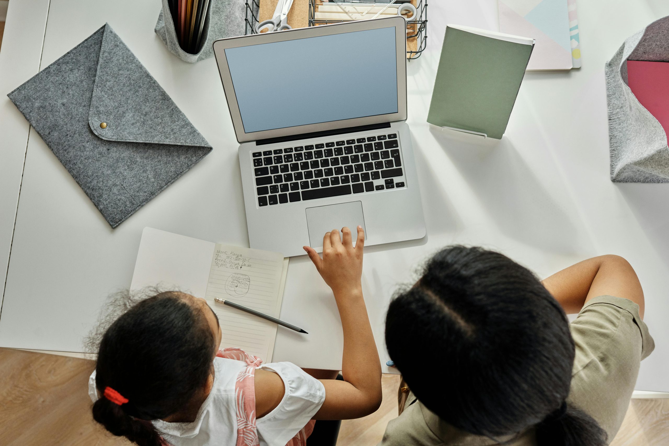 Two youthful asian students doing English Second Langauge homework on a laptop. 